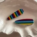 Dettaglio di fermagli per capelli in acrilico a righe arcobaleno su un vassoio di ceramica - Arcobaleno Profondo