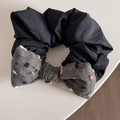 Detailansicht eines schwarzen Haargummis mit grauem Polka-Dot-Bogen und Bommelverzierung - Schwarzgrau Schleife Haargummi mit 3D-Punkten