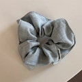 Detailed view of grey checkered scrunchie fabric and Have a nice day label - Pale Green Scrunchie
