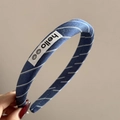 Detail of blue striped fabric headband featuring a white Hello label with smiley icons - Hello Striped Style (FQ881417)