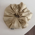 Gros plan sur un chouchou en denim beige avec étiquette de marque et texture sergé - Jaune