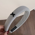 Detail of handmade black and white striped headband with a cross bow and woven label - Black Striped Bow Headband