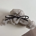 Close-up of elegant champagne grey pleated tulle hair claw with dark brown ribbon bow detail - Gray