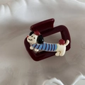 Detail of burgundy square hair claw clip featuring a cute cartoon dachshund wearing a sweater - Blue Striped Dog - Small Square Claw