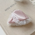 Close-up of pink satin hair accessories with double-layered white lace trim on vintage book - Pink Hair Claw