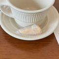 Close-up of iridescent acetate triangular hair clip on an elegant ceramic saucer - Rainbow