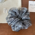 Detail of dark grey polka dot organza scrunchie on a wooden surface for hair styling - Gray Polka Dot
