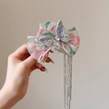 Detalle de pinza de pelo con lazo de malla floral rosa, pedrería brillante y borlas de metal - Rosa