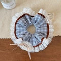 Detail of blue plaid scrunchie with lace trim, ribbon bow, and Good Luck metal charm - Blue Plaid