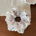 Vista detallada de un coletero de encaje floral vintage sobre fondo de mesa de madera - Estilo de Encaje Floral Blanco Roto