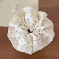 Close-up of polka dot fabric scrunchie with delicate lace edges on a wooden surface - Beige Polka Dot
