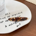 Détail macro d'une barrette en acétate écaille de tortue avec lettrage élégant - Pince À Bec De Canard Ovale / Brun Ambré