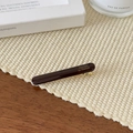 Nahaufnahme einer braunen Baguette-Haarspange mit goldener Aufschrift Barrette la France - Dunkelkaffee