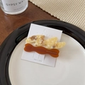 Détail de deux barrettes irrégulières en acétate aux couleurs marbre et ambre - Caramel Crème