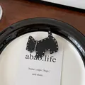 Detalle macro de una pinza para el pelo de acetato negro con forma de perro y cristales - Negro