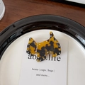 Detalle del pasador de perro en carey con pedrería brillante sobre bandeja blanca - Estampado de leopardo