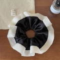 Detail of satin scrunchie with white lace trim on a dark wood background - Black Contrast Scrunchie