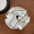 Detalle de un coletero grande de encaje con lunares sobre madera oscura - Lunares Blancos de Cuatro Capas