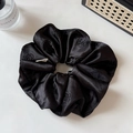 Detail of black satin hair scrunchie with camellia embroidery and minimalist label - Black