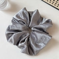 Detail of silver grey satin scrunchie featuring elegant rose floral embroidery - Gray