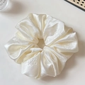 Detail of elegant cream satin scrunchie featuring a delicate rose floral texture and soft sheen - Off-white