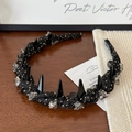 Dettaglio di cerchietto nero a pois dorati con cristalli e borchie su sfondo legno - Nero Pois Stile Spikes / Nero