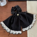 Detail of black pleated scrunchie with white lace edges and a gold metal charm - Black