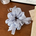 Detail shot of light purple organza scrunchie with soft mesh texture on wooden surface - Blue