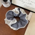 Gros plan du chouchou à carreaux noirs et blancs avec bordure en dentelle beige - Chouchou Petit Plaid