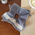 Detail of blue plaid hair scrunchie with white lace edges on a rustic wooden desk - Blue and White Checkered