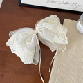 Dettaglio del fermaglio per capelli a fiocco in pizzo crema con ricami floreali fini - Fermaglio Coda Pizzo Bianco Crema