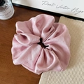 Detailed macro view of pink satin pleated hair scrunchie with sparkling rhinestones - Pink