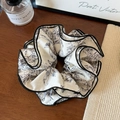 Detail eines eleganten vierlagigen Scrunchies mit Tuschedruck, schwarzer Paspel und Blumenmuster - Vintage Blumendruck