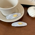 Détail de barrettes à carreaux gris avec plaques dorées et gravure de nœud élégante - Paire de barrettes café
