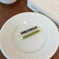 Detailed macro of tortoise shell and olive green acetate hair clips on ceramic plate - Dark Tortoiseshell