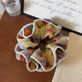 Detail of oil painting floral scrunchie with delicate stitching on a vintage wooden desk - Head Flower Style