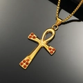 Macro shot of gold Ankh cross pendant with orange rhinestones on a black reflective base - Gold Color Orange Rhinestone Pendant Only (Without Chain)