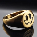 Polished gold signet ring with black melting smiley face pattern on black reflective surface - US 7 / Gold