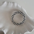 Dettaglio dell'elastico per capelli a spirale con design a pois neri su un vassoio - Trasparente a Pois