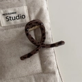 Dettaglio della molletta per capelli leopardata con finitura lucida e molla in metallo dorato - Leopardo Scuro-Stile Croce