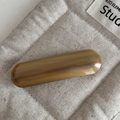 Detailed shot of amber acetate spring clip showing the France Handmade engraving - Dark Apricot
