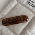 Detail view of handmade tortoiseshell acetate hair clip with elegant gold lettering - Blue Coffee
