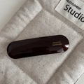 Close-up of a handmade dark brown acetate spring hair clip with gold lettering - Brown