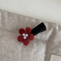 Close-up of red flower hair clip featuring white pearls and black velvet band texture - Flower Pearl Clip