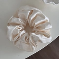 Detalle de coletero grande de satén crema con textura de seda y pliegues elegantes - Blanco Roto
