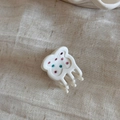 Detail showing a white acetate bear hair claw clip with pink and teal rhinestones - Bear Style / White