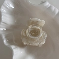 Details der cremeweißen Rosen-Haarklammer mit Marmortextur auf einer weißen Schale - Gemischtes Weiß