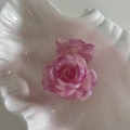Detalle de pinza de pelo rosa con brillo y textura floral en bandeja de concha - Rosa intenso