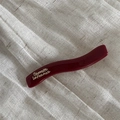Detail of a wavy dark red glossy hair clip with gold French lettering on linen - Wave Shape - Wine Red