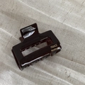 Detail of high-gloss tortoiseshell hair claw showing gold handmade France lettering - Dark Coffee